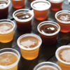 A table of beer samples in plastic cups